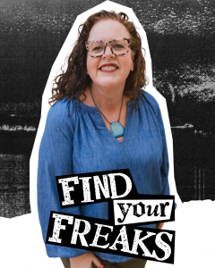 Kathi Lipp has curly red hair, tortishell glasses and the sweetest impish smile you can imagine. She's wearing a bohemian style chambray shirt with chunky statement necklace.
